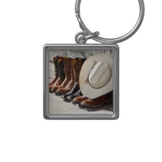 Cowboy hat on row of cowboy boots outside a log key chains
