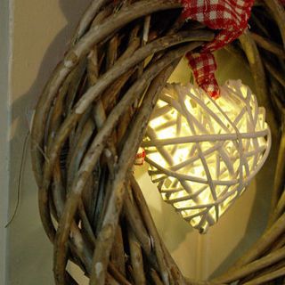 wicker wreath with lights by boxwood