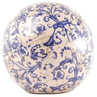 blue and white aged ceramic decorative ball by the orchard